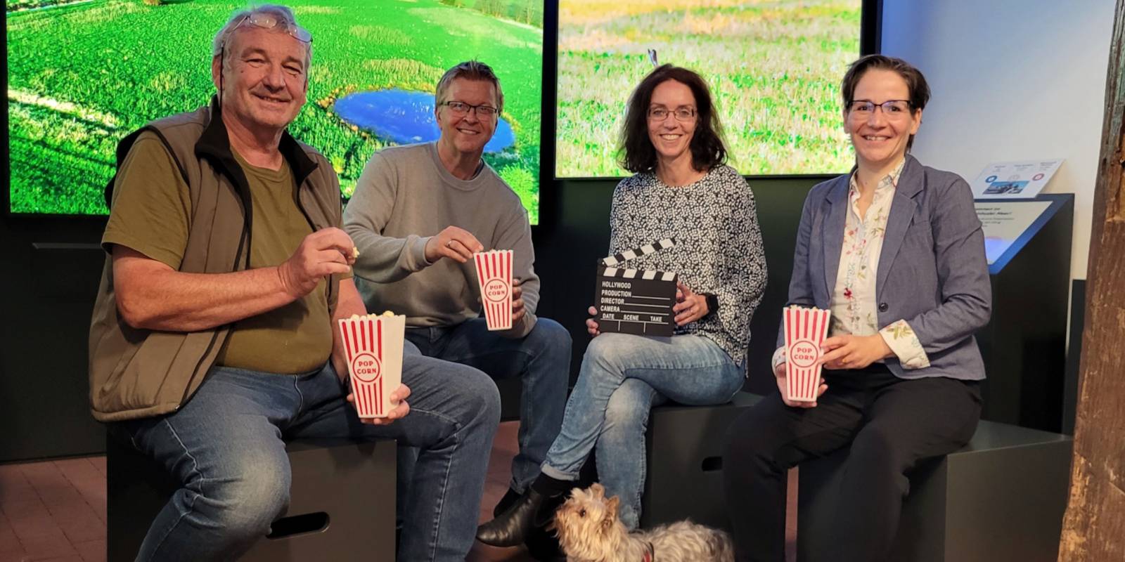 Zwei Männer, zwei Frauen und ein Hund sitzen mit Popcorn im Infozentrum Steinhude.