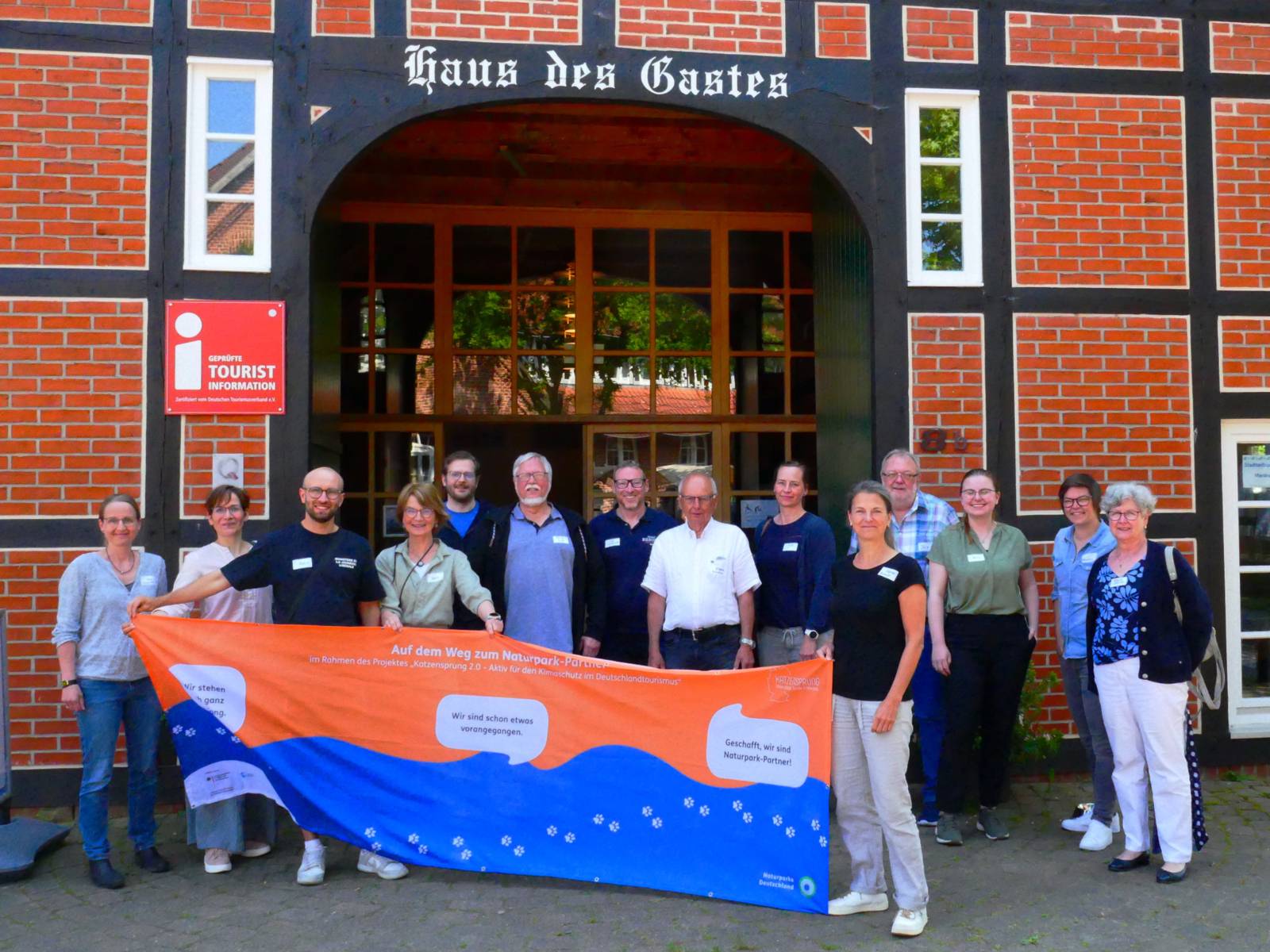 Mehrere Personen vorm Haus des Gastes in Mardorf, einige halten ein Banner.