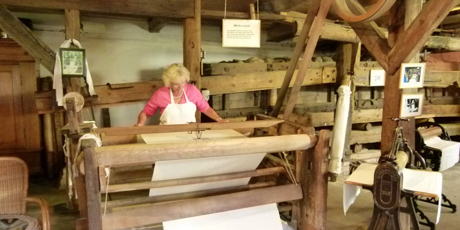 Eine Frau arbeitet an einer historischen Kastenmangel