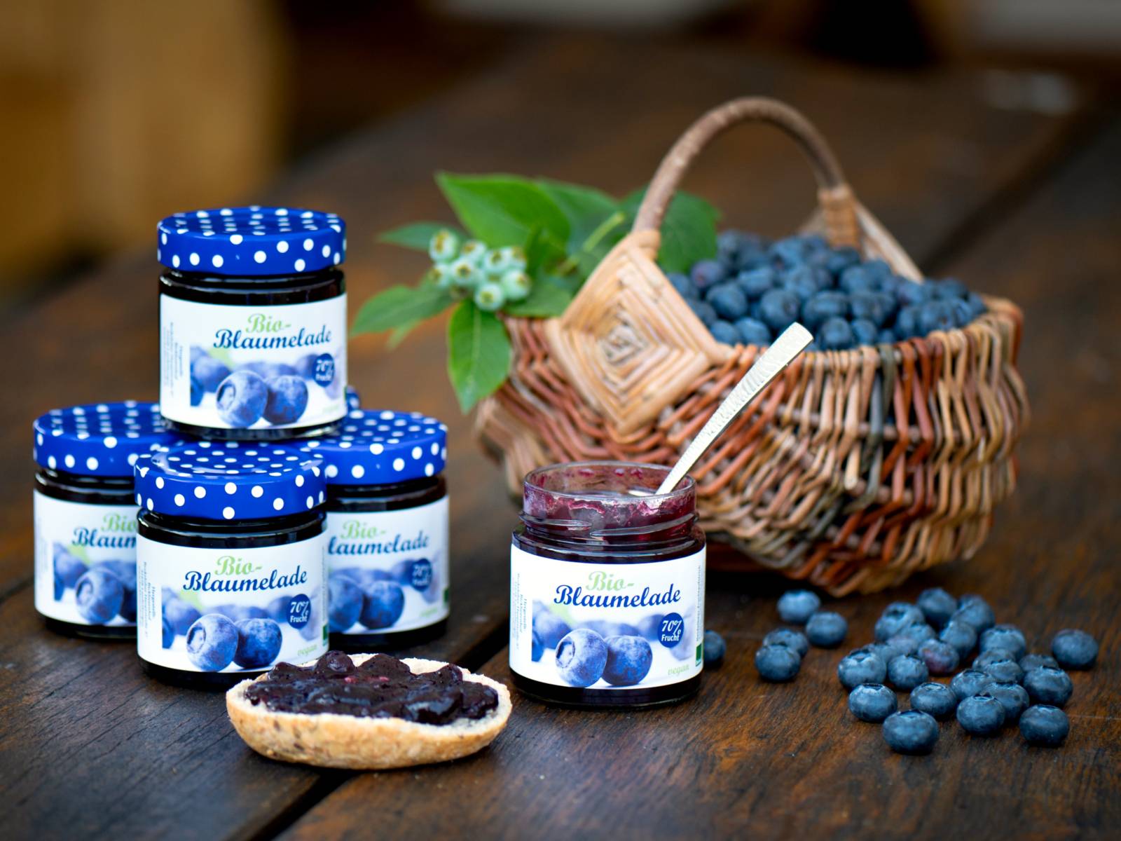 Heidelbeeren und Gläser mit Fruchtaufstrich auf einem Tisch