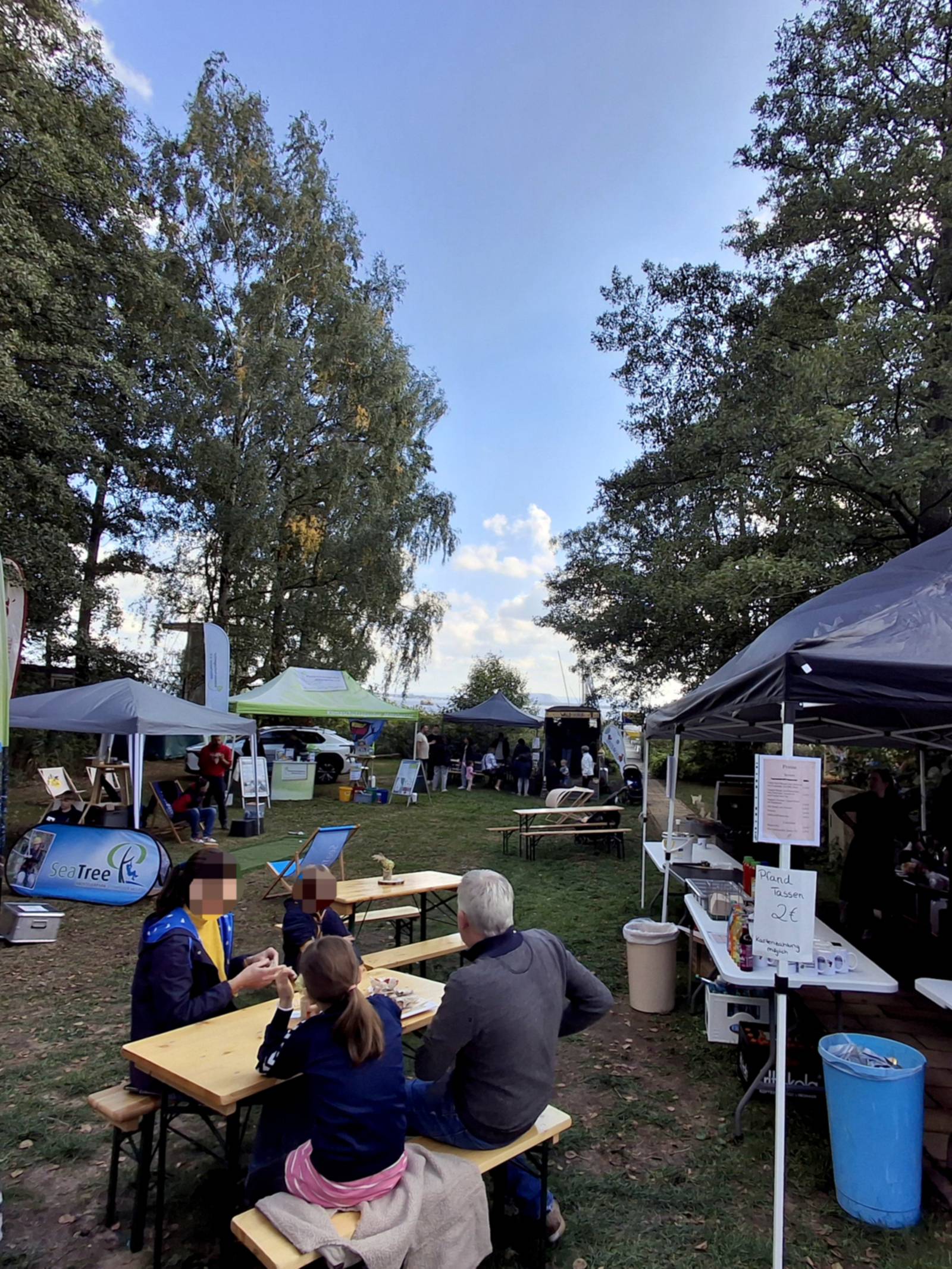 Blick über einen Rastplatz zum Steinhuder Meer, Zelte und Stände empfangen Gäste.