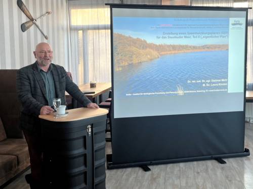 Ein Mann steht an einem Pult und präsentiert.