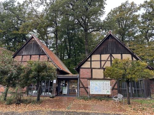Zwei Fachwerkscheunen bilden ein großes Gebäude, Schilder weisen auf das "Infozentrum Steinhude Naturpark Steinhuder Meer" hin.