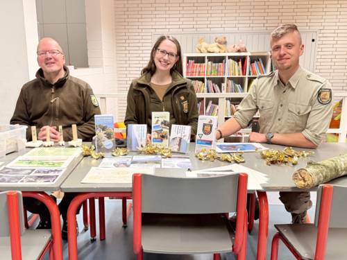 Das Ranger-Team sitzt an kleinen M&ouml;beln.