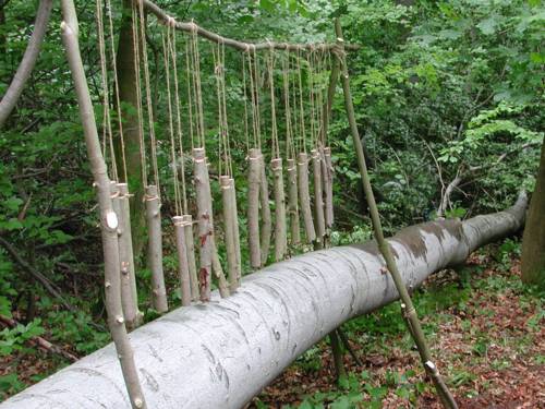 Holzstücke hängen in verschiedenen Längen an einem Ast und bilden so ein Xylophon