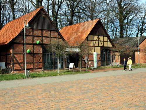 Zwei Fachwerkscheunen bilden ein großes Gebäude, Schilder weisen auf das "Infozentrum Steinhude Naturpark Steinhuder Meer" hin.