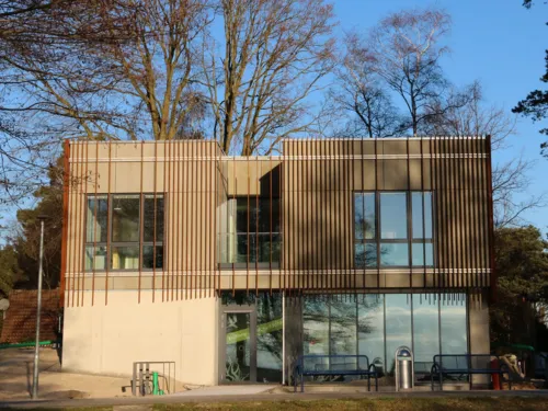 Modernes Gebäude mit flachem Dach und einer Fassade mit Metallstreben.
