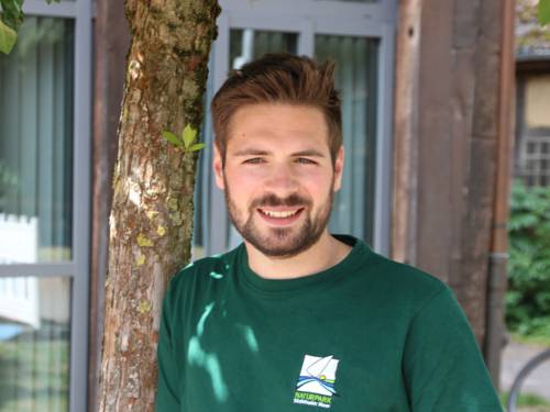 Porträt eines Mannes, er trägt ein grünes T-Shirt mit dem Logo des Naturparks Steinhuder Meer.