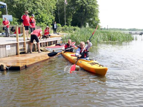 Ein Boot mit zwei Personen legt von einer Kanueinsatzstelle ab.