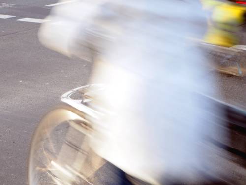 Aufnahme mit Bewegungsunschärfe und Dynamik: Der Radweg ist scharf. Die sich bewegenden Radfahrer sind bewegungsunscharf.