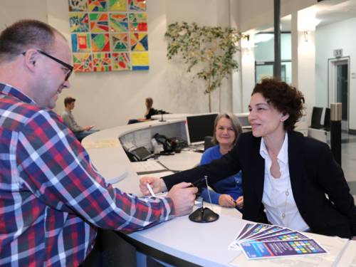 Einige Menschen an einem Tresen im Bürgerbüro der Region Hannover