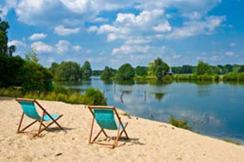 Zwei Sonnenliegen am Strand ausgerichtet mit Blick auf das Wasser.