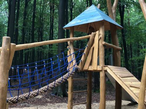 Kletterturm auf einem Spielplatz in einem Wald.