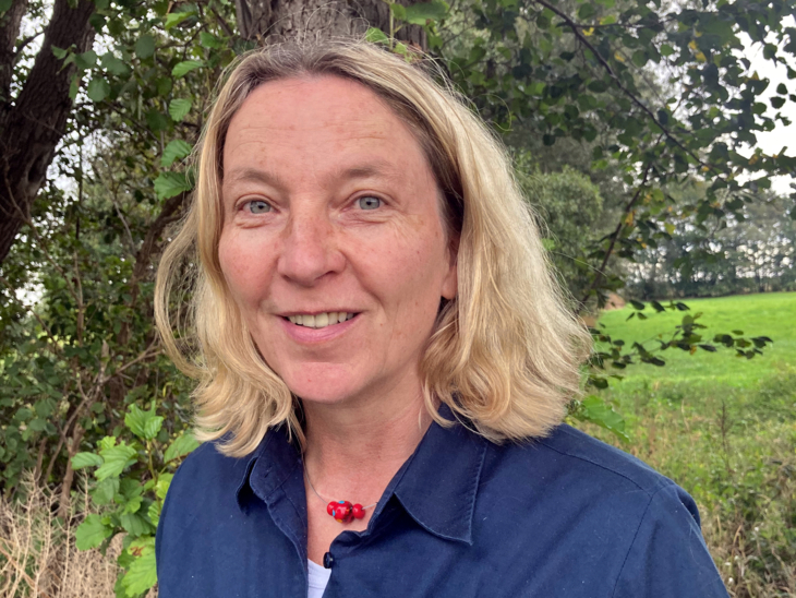 Porträtfoto einer Frau in einem blauen Poloshirt mit Naturparklogo.