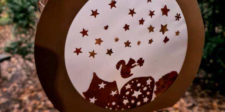 Laterne mit kleinen Eichhörnchen als Dekoration.