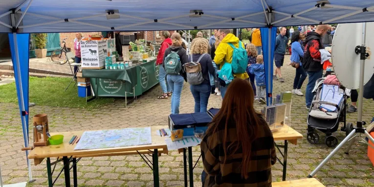 Blick von hinten durch einen Aktionsstand auf einen Markt.