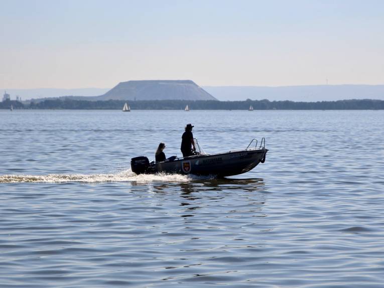 Zwei Personen fahren mit einem kleinen Motorboot über das Steinhuder Meer.