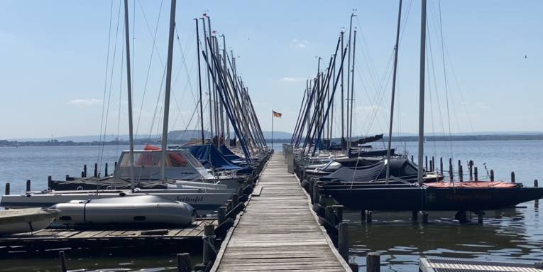 Blick einen Steg entlang, links und rechts liegen Boote.