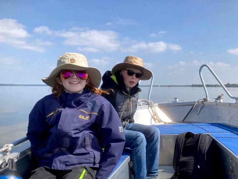 Zwei Kinder sitzen in einem Boot.