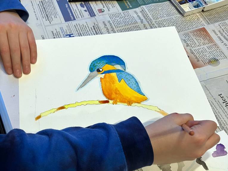 Ein Aquarell entsteht: Eisvogel auf einem weißen Blatt Papier