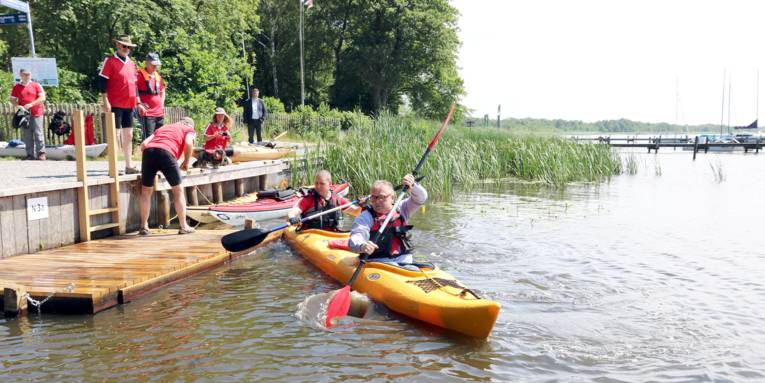 Ein Boot mit zwei Personen legt von einer Kanueinsatzstelle ab.