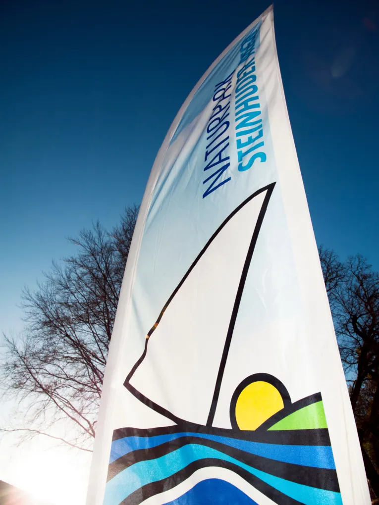 Freistehende Fahne mit dem Logo des Naturparks Steinhuder Meer