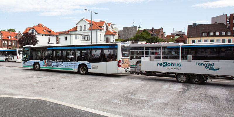 Hinter einem Linienbus hängt ein Anhänger. Hinter einem Linienbus hängt ein Anhänger.
