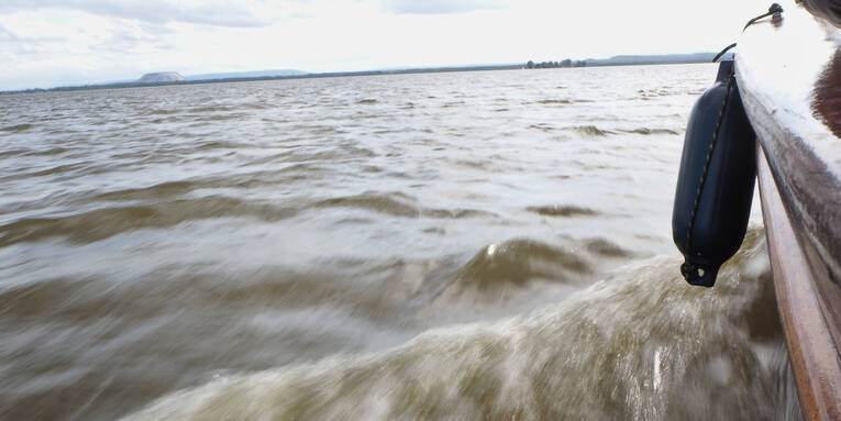 Ein Boot schiebt eine kleine Bugwelle vor sich her. Ein Boot schiebt eine kleine Bugwelle vor sich her.