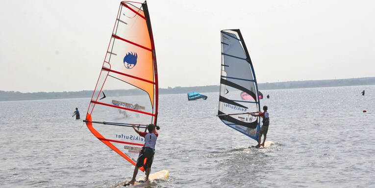 Zwei Windsurfer betreiben Wassersport auf dem Steinhuder Meer. Zwei Windsurfer betreiben Wassersport auf dem Steinhuder Meer.